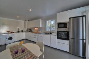 a kitchen with a table and a stainless steel refrigerator at Villa Vistamar in Cala d´Or