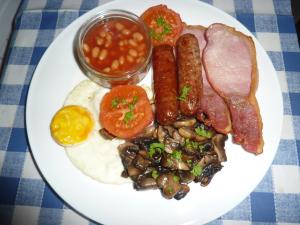talerz jedzenia śniadaniowego z jajkami, kiełbasą i fasolą w obiekcie Snipelands Bed and Breakfast. w mieście Flax Bourton