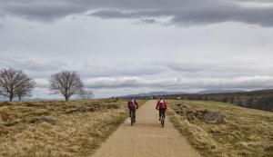 dos personas montando bicicletas por un camino de tierra en El Txakoli en Amurrio