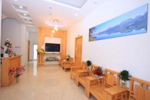 a waiting room with wooden benches and a flat screen tv at Moc Tra Hotel in Da Lat