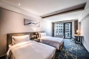 Voodi või voodid majutusasutuse Q-Box Hotel Shanghai Sanjiagang -Offer Pudong International Airport and Disney shuttle toas