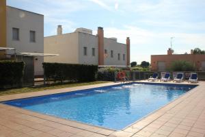 a swimming pool with chairs and a building at Hotur Via Augusta in Creixell +7 photos