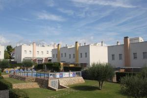 a resort with a swimming pool and white buildings at Hotur Via Augusta in Creixell
