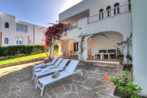 a group of white lounge chairs on a patio at Villa Vistamar in Cala d´Or