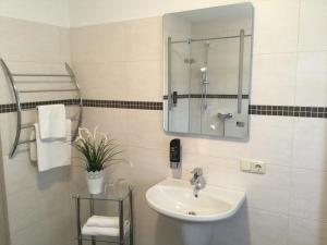 a bathroom with a sink and a mirror at Landgasthof & Hotel Jossatal in Breitenbach am Herzberg