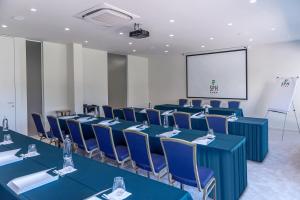 a conference room with blue tables and chairs and a screen at San Paolo Hotel in Montegiorgio +23 photos