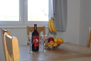 una mesa con una botella de vino y una cesta de fruta en Andrea Apartments, en Trogir