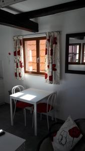 ブーウィラーにあるComme une tour dans le centre Historiqueの窓付きの客室で、白いテーブルと椅子が備わります。