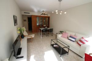 sala de estar con sofá blanco y mesa en Apartamento Blau Marí, en Cambrils