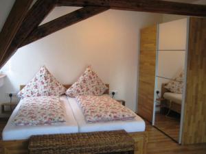 a bedroom with a bed with pillows and a mirror at Haus Gartentraum in Sommerhausen