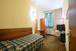 a hotel room with a bed and a flat screen tv at Hotel Eden in Turin