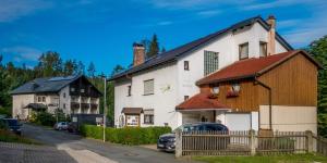 une grande maison blanche avec un toit marron dans l'établissement Landhaus am Forst - Apartments, à Bad Alexandersbad