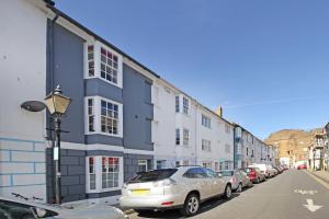 a row of buildings on a street with parked cars at Brighton's Best BIG House - Sleeps 12 to 18 guests - 4 bedrooms in Brighton & Hove