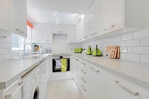 a white kitchen with white counters and white appliances at Brighton's Best BIG House - Sleeps 12 to 18 guests - 4 bedrooms in Brighton & Hove