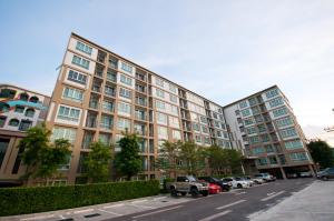 a large building with cars parked in a parking lot at Baan Imm Aim Condo Hua Hin in Hua Hin