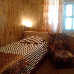 een slaapkamer met een bed, een stoel en een raam bij Expo Home Stay in Boekarest