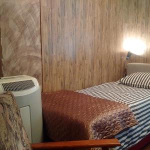 een kleine slaapkamer met een bed en verwarming bij Expo Home Stay in Boekarest