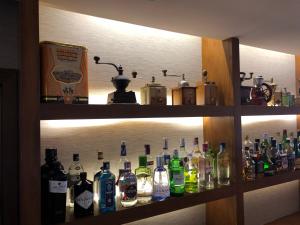 een plank gevuld met veel flessen alcohol bij Hotel Parque das Laranjeiras in Vilamoura