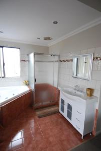 uma casa de banho com uma banheira, um lavatório e um chuveiro em Mountain Park Retreat em Perth