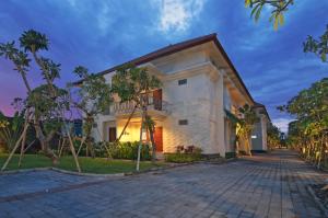 a large white house with a driveway at Taman Ayu Town House in Denpasar
