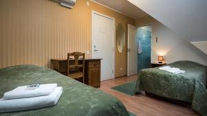 a room with two beds and a desk and a mirror at Sangaste Rukki Maja Guesthouse in Sangaste