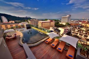a balcony with a pool and chairs and buildings at The Sun Xclusive in Pattaya South