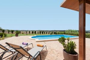 patio z krzesłami i basenem w obiekcie Villa Es Moli - Son Femenia w mieście Santa Margalida