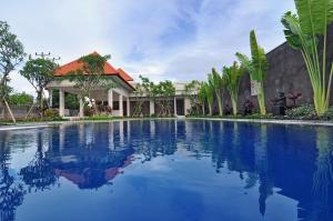 a swimming pool in front of a house at Taman Ayu Town House in Denpasar