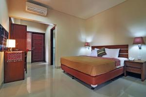 a bedroom with a bed and a table and a door at Taman Ayu Town House in Denpasar +22 photos