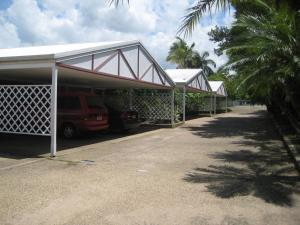 Beenleigh Village Motel في بينلبيه: carport with a van parking lot