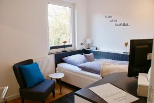 a living room with a couch and a window at Deichhotel Rose in Juist