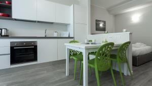 een keuken met een witte tafel en groene stoelen bij Italianway-Cadorna 10B in Milaan