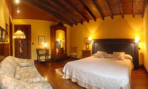 a bedroom with a large bed and two chairs at Posada Andariveles in Quijas