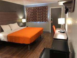 Habitación de hotel con cama con manta naranja en Super 8 by Wyndham Sonora, en Sonora