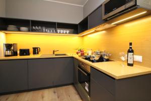 una cocina con armarios negros y una pared amarilla en Tallinn City Apartments Old Town Suites, en Tallin
