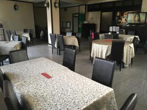 une salle à manger avec des tables, des chaises et une télévision dans l'établissement Pensiunea Belvedere, à Craiova