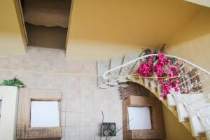 a spiral staircase with pink flowers on it at Sant Orsla Suite in Valletta