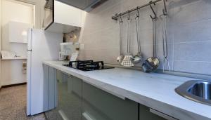 a kitchen with a counter with a sink and a refrigerator at Italianway-Abba in Milan