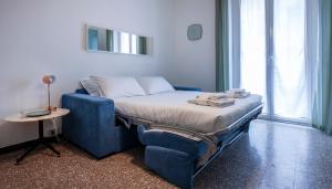 a bed in a room with a blue chair and a table at Italianway-Abba in Milan