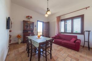a living room with a table and a red couch at Casa Elena in Trapani