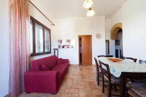 a living room with a red couch and a table at Casa Elena in Trapani