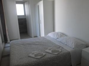 ポリニャーノ・ア・マーレにあるAffittacamere Nemoのベッドルーム1室(ベッド1台、タオル2枚付)