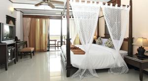 a bedroom with a canopy bed and a television at Pattaya Loft in Pattaya Central