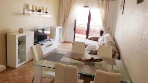 sala de estar con mesa de comedor y sofá en Orihuela Costa Costamarina Cabo Roig Apartamentos TIKASA, en Cabo Roig