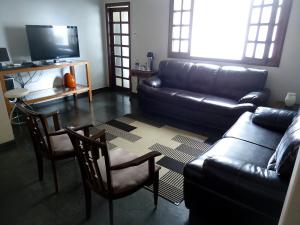 a living room with a black leather couch and chairs at Del Rey Hotel in Barbacena