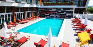 a pool with chairs, tables, chairs and umbrellas at Yalova Lova Hotel & SPA Yalova in Yalova