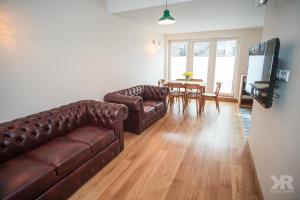 a living room with two leather couches and a table at Maria 4 Apartment in Tartu