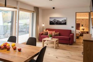 a living room with a red couch and a table at Alpine Chalets App. Pichlerhof in Brunico