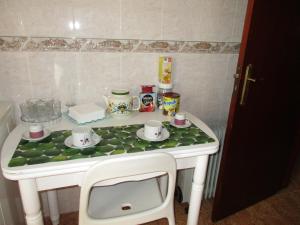 a table with cups and saucers on top of it at Pousada Ibérica Sobralense in Sobral de Monte Agraço