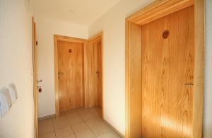 a hallway with two wooden doors in a room at House Marinic in Grabovac